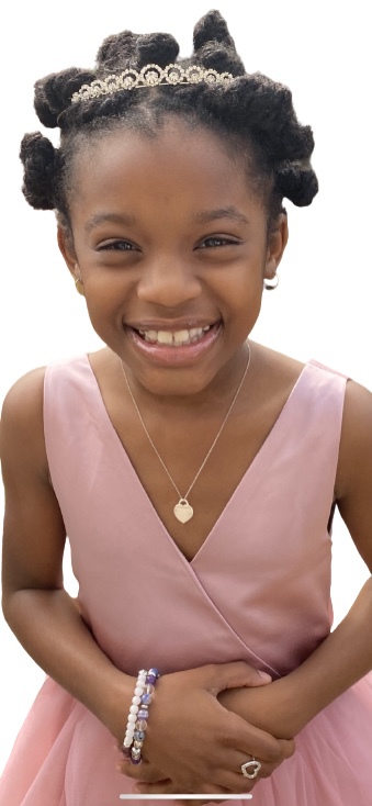 Jazmin "Jazz" Headley smiling wide in a gorgeous pink dress on her ninth birthday 