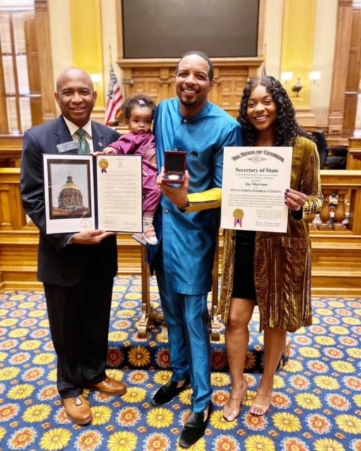 Senator Lester Jackson awarding Jay Morrison the Outstanding Georgia Citizen Award. Ernestine Morrison and Kobe Morrison also pictured.