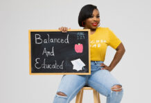 Applemania Bradford Champions Wellness for Educators Applemania Bradford, founder and CEO of Teacher B.A.E., holds a Balanced and Educated chalkboard.